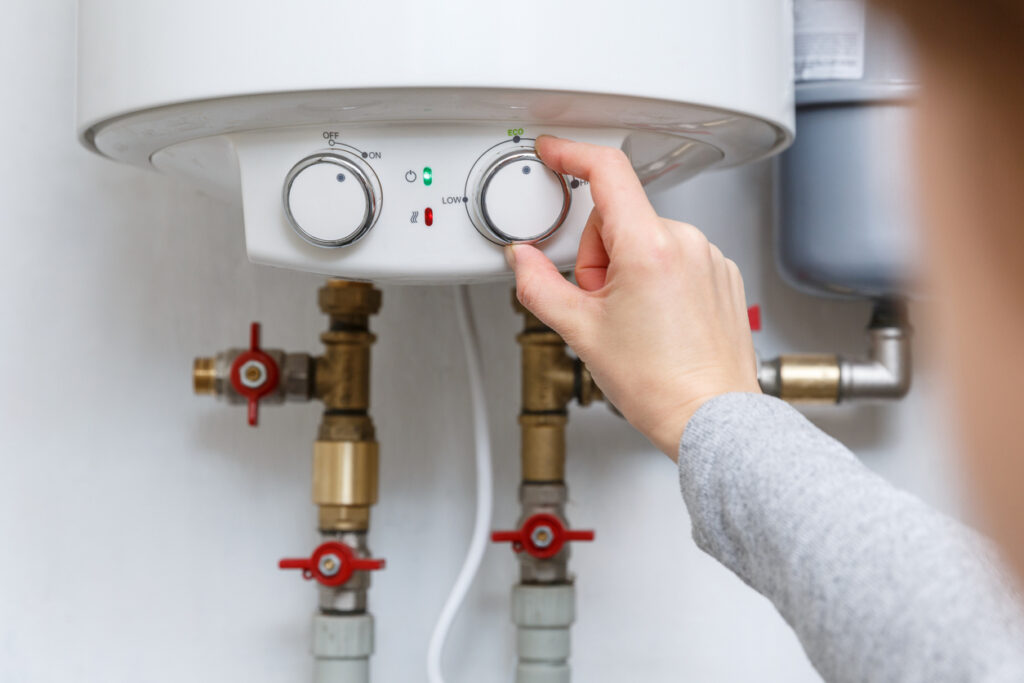Female Hand Adjusting Tankless Water Heater