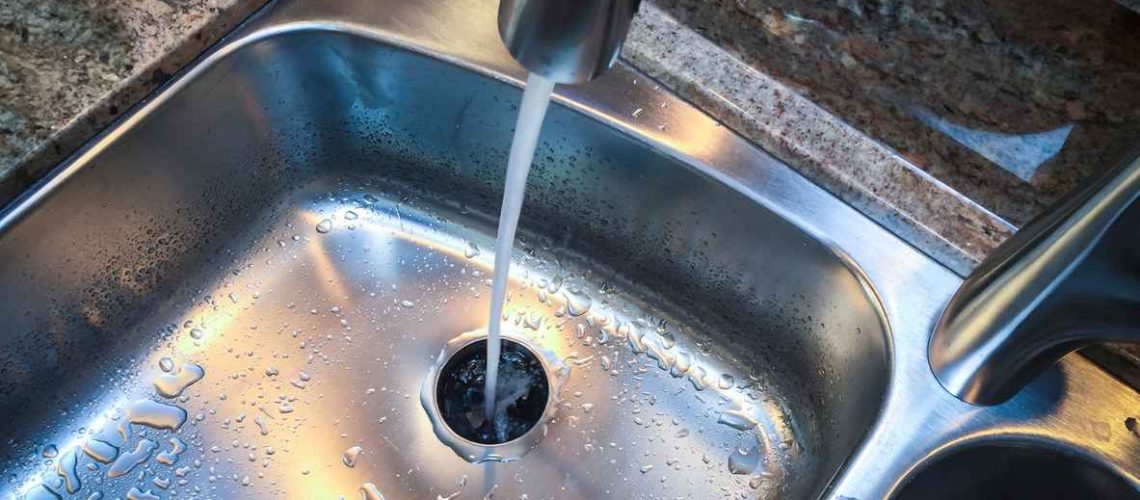 Water down the drain of kitchen sink.
